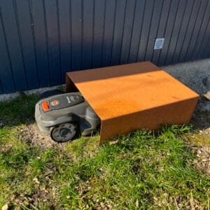 Robotplæneklipper under robotplæneklipperskjuler i cortenstål.
