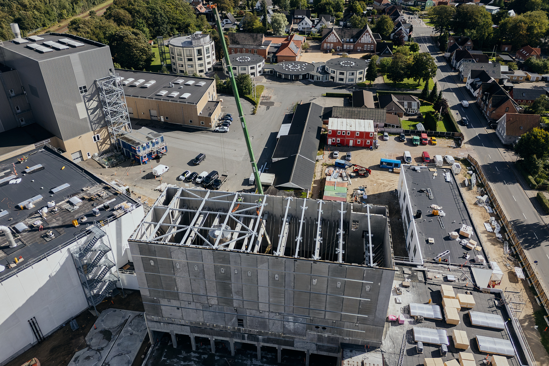 Luftfoto af industribyggeri under opførelse med kran